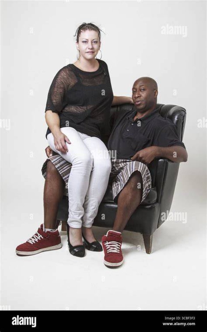 a man and woman sitting in the back of a car