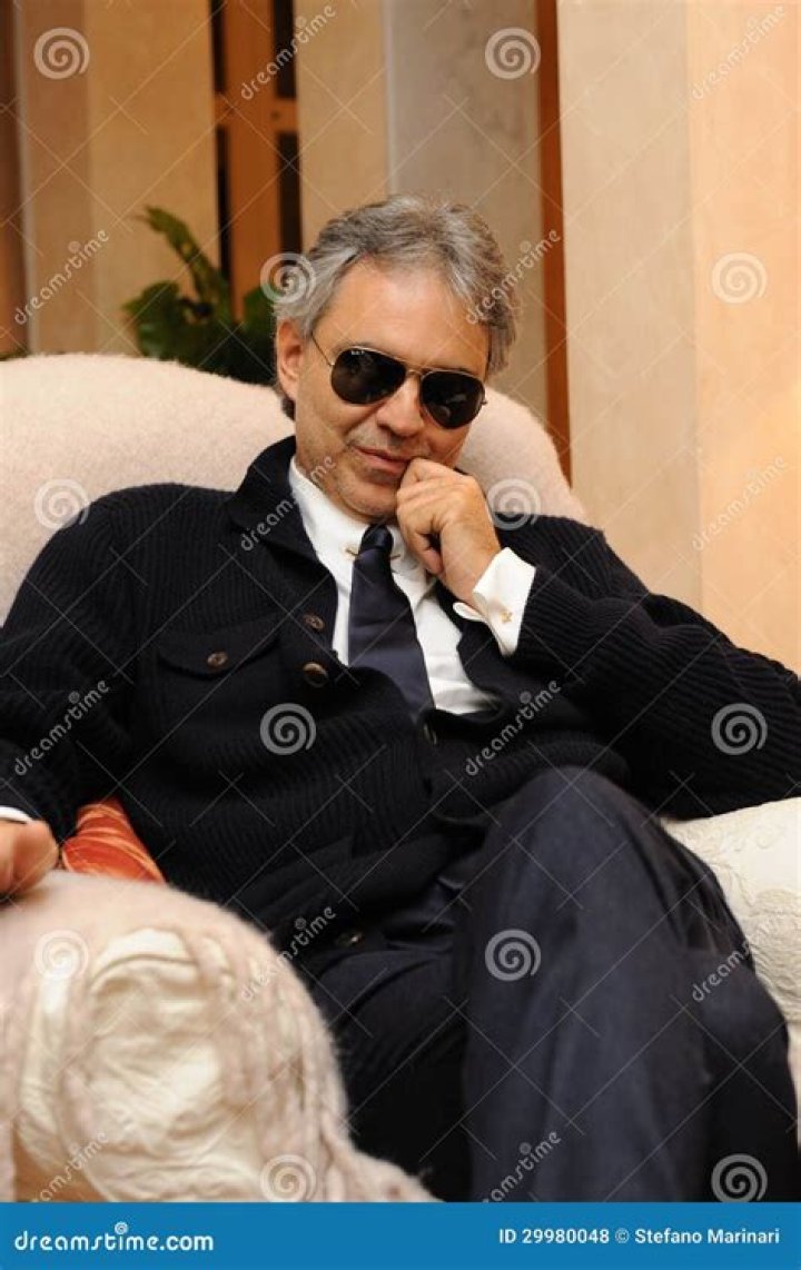Andrea Bocelli in an armchair with his wife Enrica Cenzatti and their