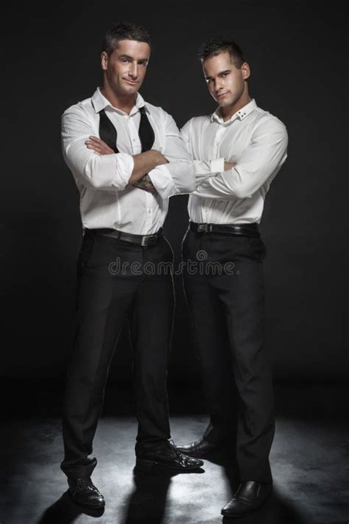 the two men are posing for pictures with their hands up and one is